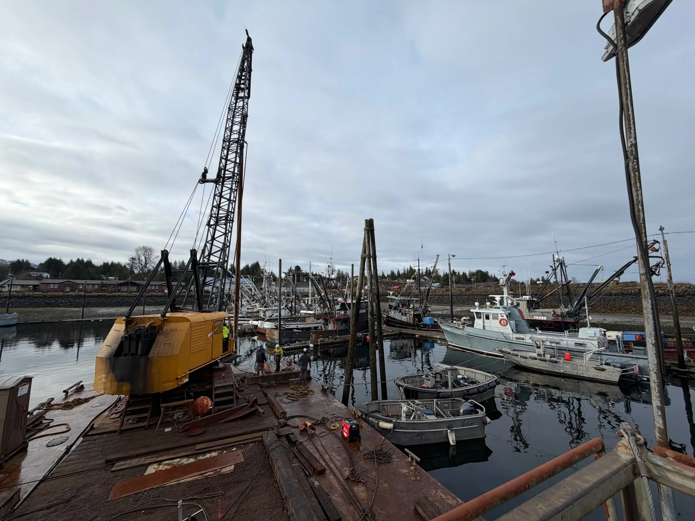 Crane barge and skiffs working a crowded harbor in Metlakatla